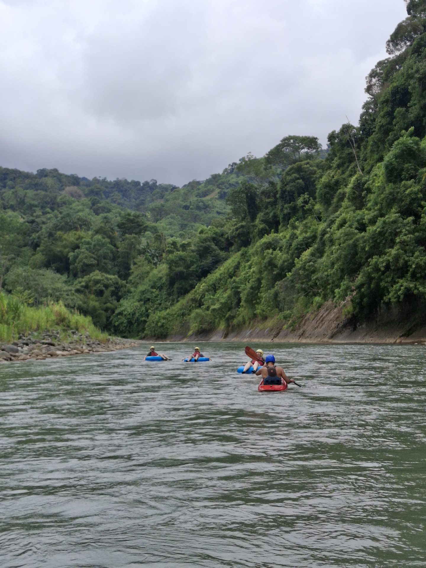 Group of guests tubing down the river with a guide in a kayak